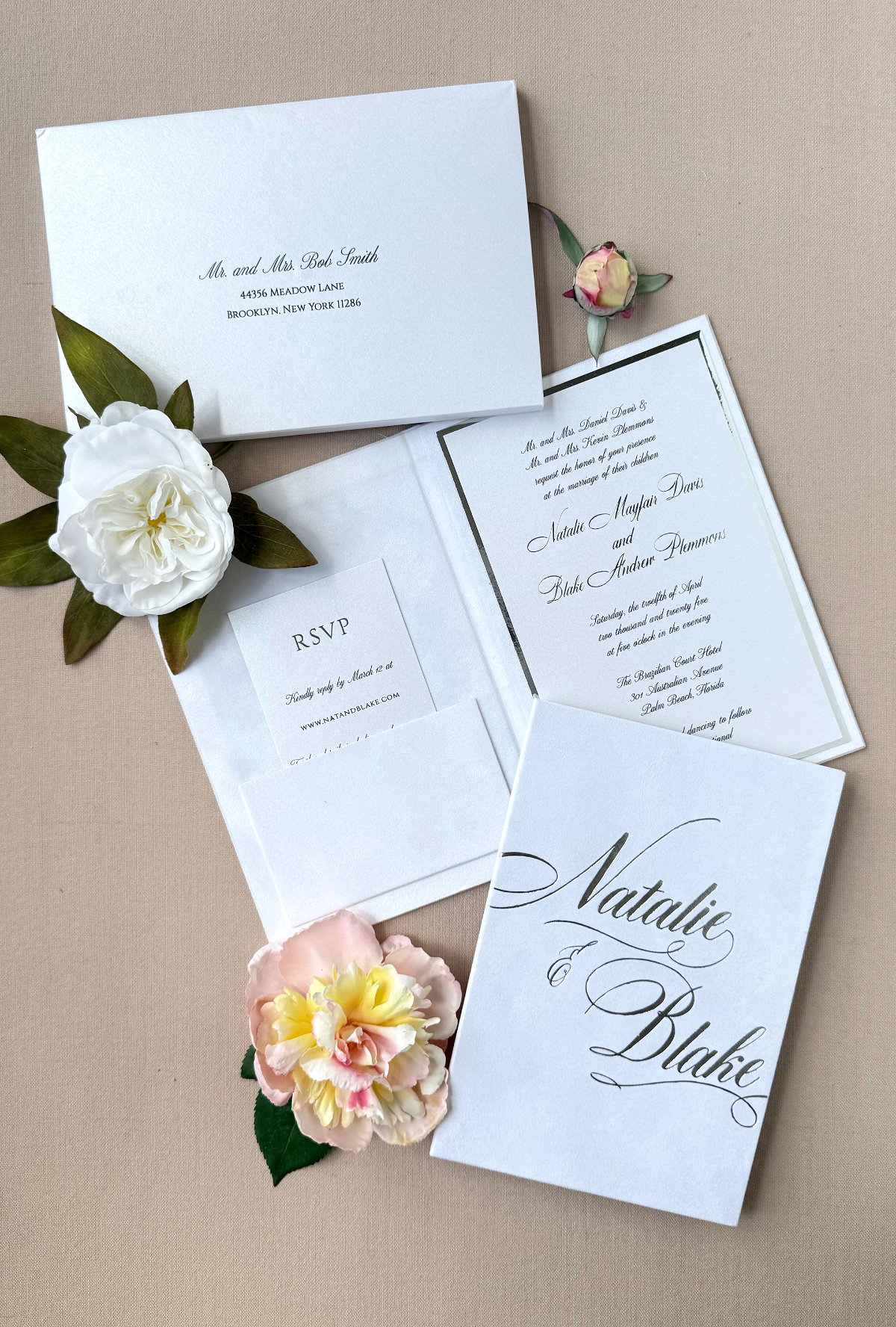 Classic white invitation suite with elegant calligraphy and soft floral styling, a timeless custom wedding invitation design focused on simplicity and graceful presentation.