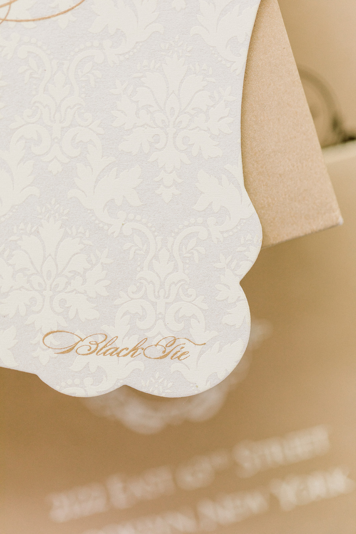 Subtle white-on-white invitation with embossed damask pattern and delicate script, a minimalist custom wedding invitation design focused on texture and quiet sophistication.